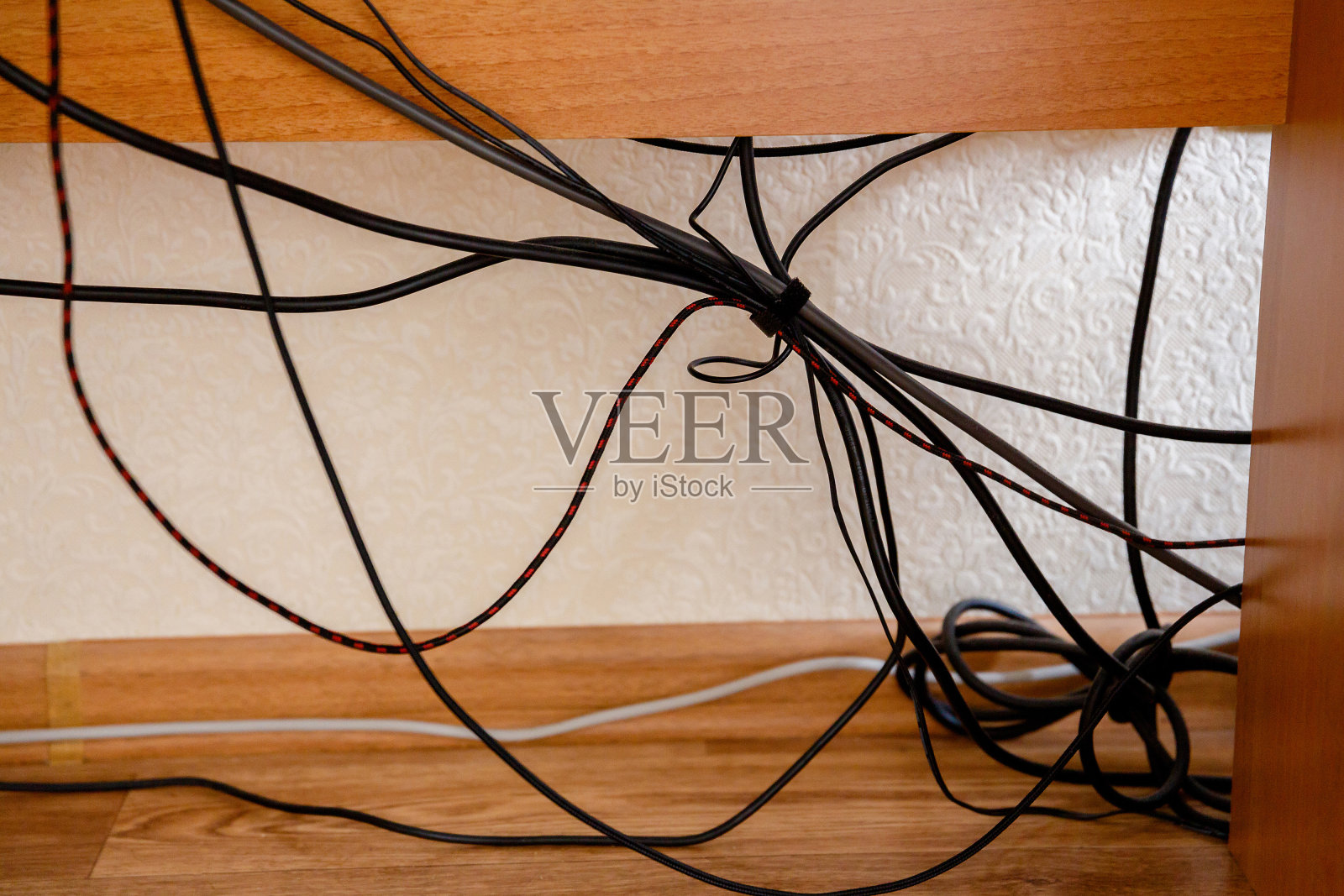 乱糟糟的电线和电缆在桌子下面照片摄影图片