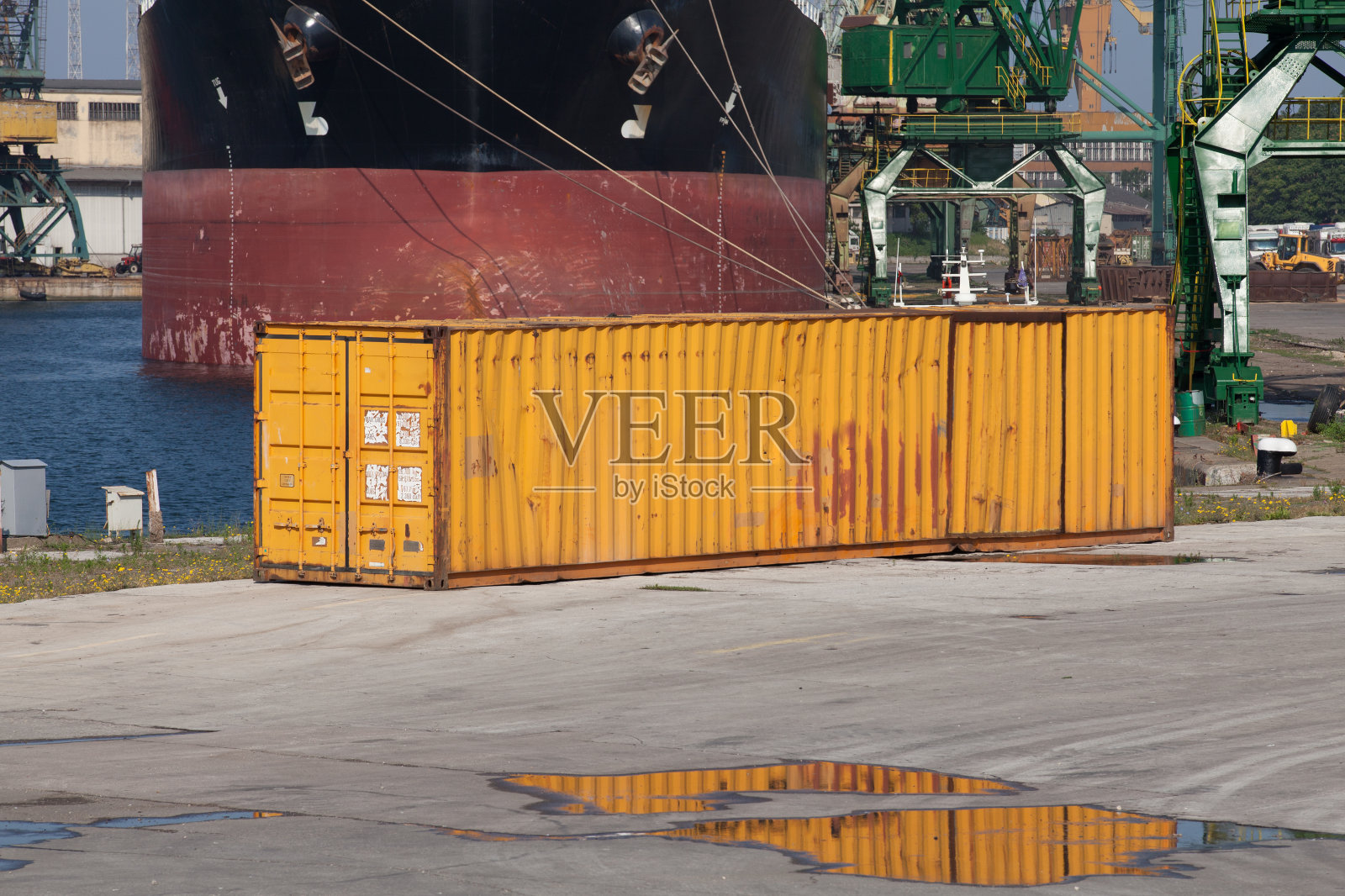 脏兮兮的黄色旧集装箱停在港口里照片摄影图片