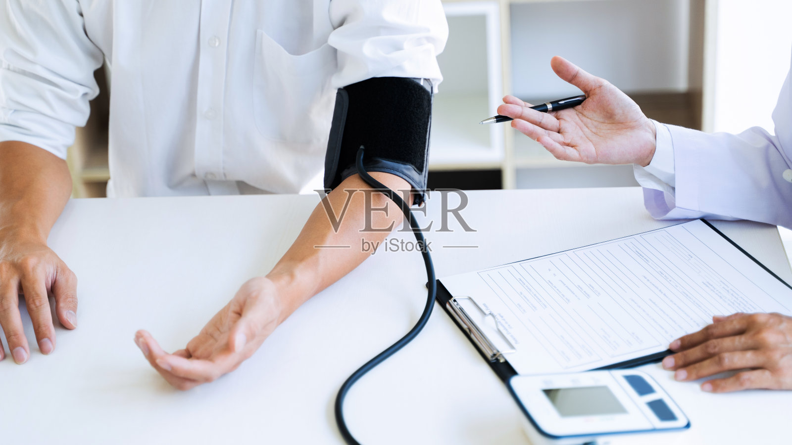 医生在医院给病人测血压。照片摄影图片