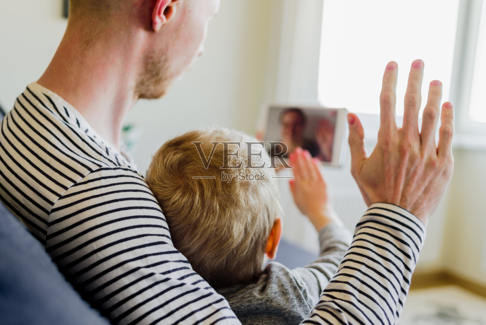 父亲和儿子给母亲打视频电话照片摄影图片