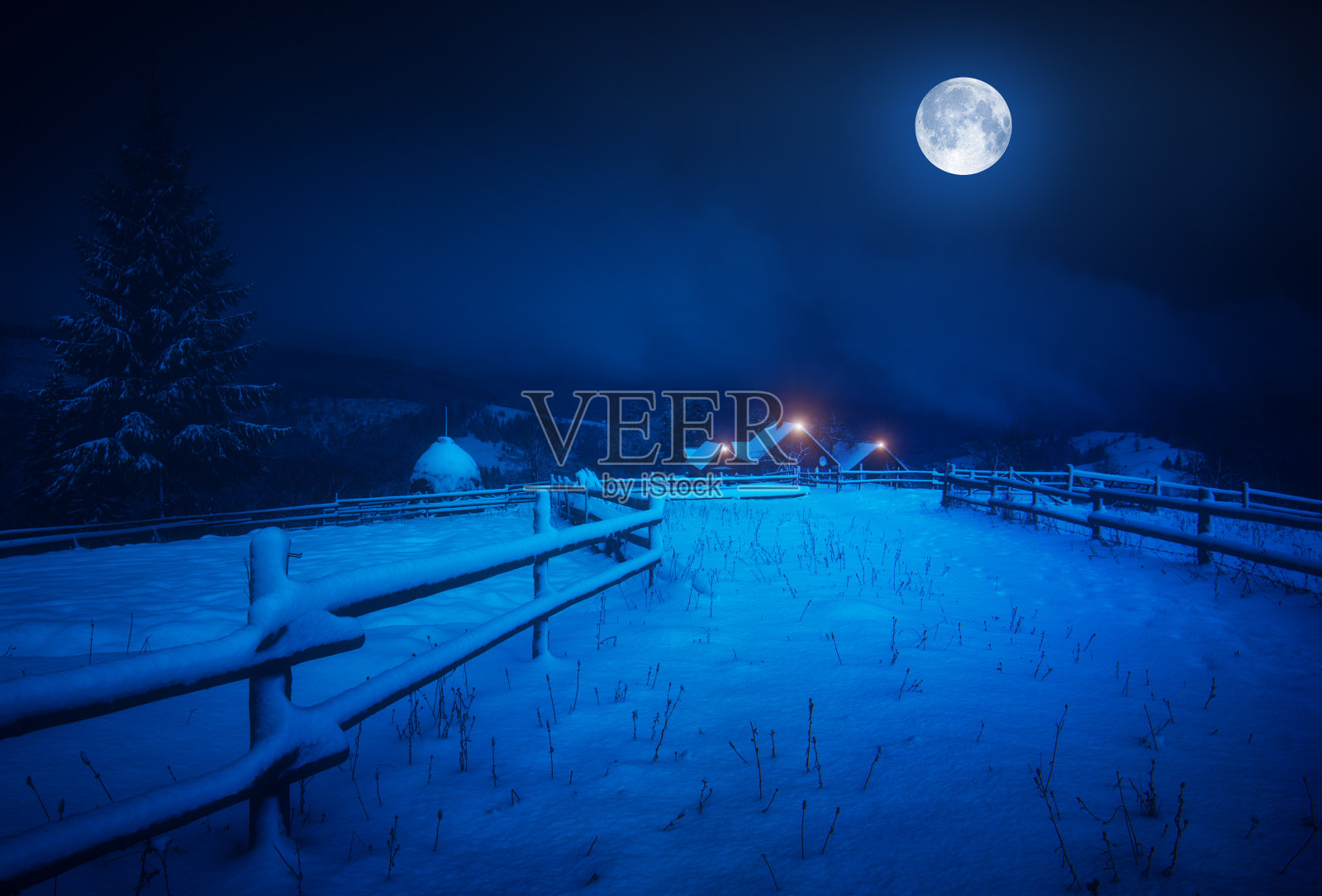 满月笼罩着白雪覆盖的村庄照片摄影图片