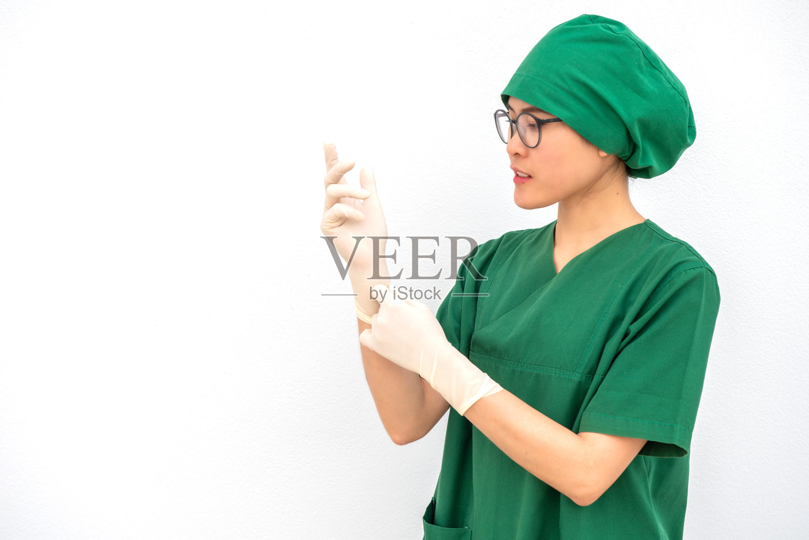 一幅亚洲护士举起双手的肖像，戴着橡胶手套在医院手术室。照片摄影图片