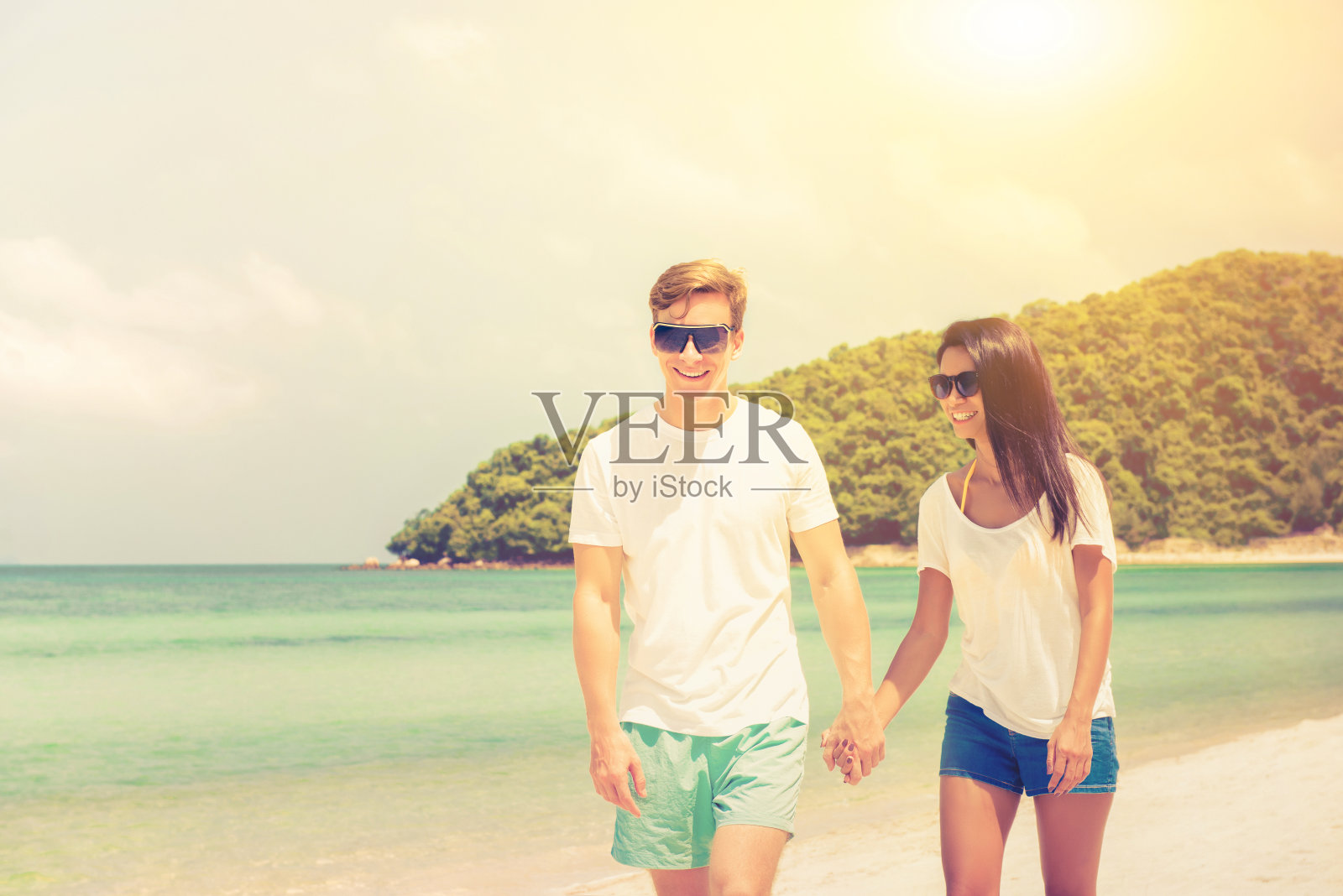 异族情侣在夏天美丽的海滩上散步照片摄影图片