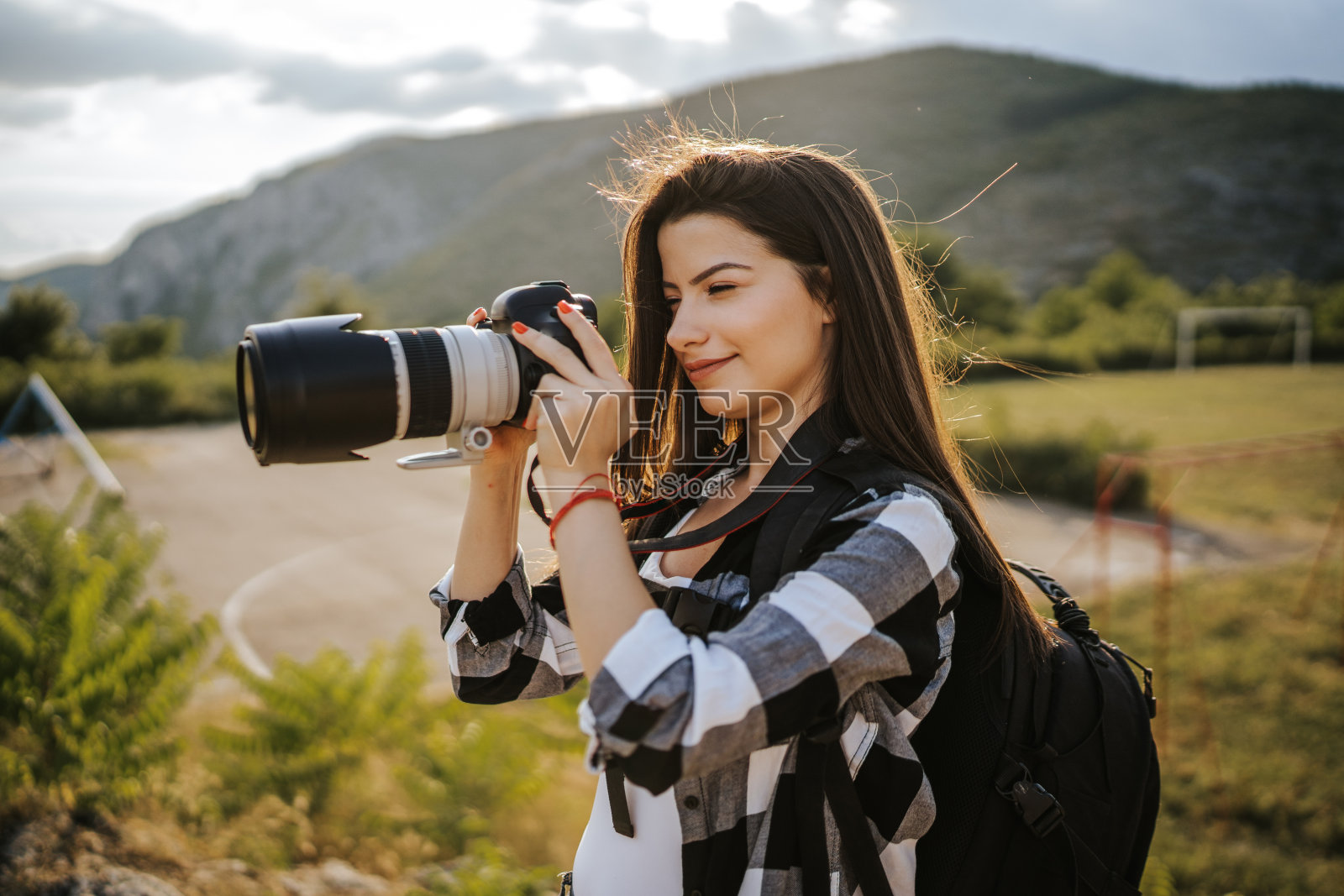 年轻的女摄影师在大自然中拍照照片摄影图片