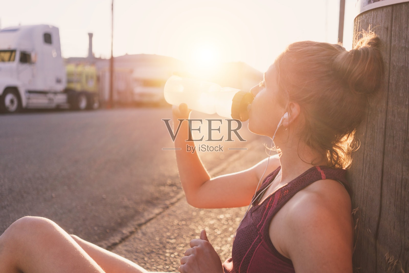 女跑步者在街上休息和喝水照片摄影图片