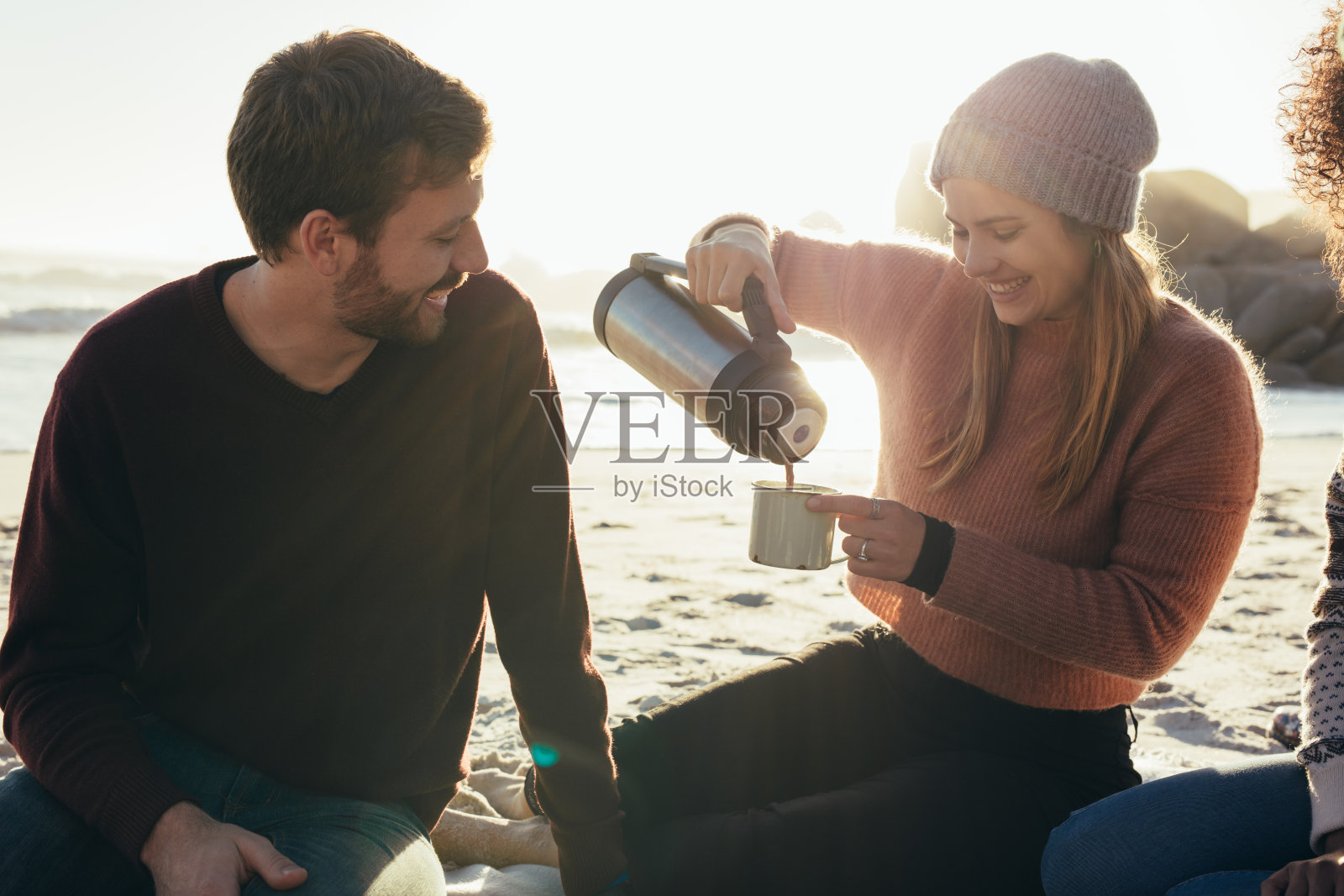 微笑的朋友在海滩上喝咖啡照片摄影图片