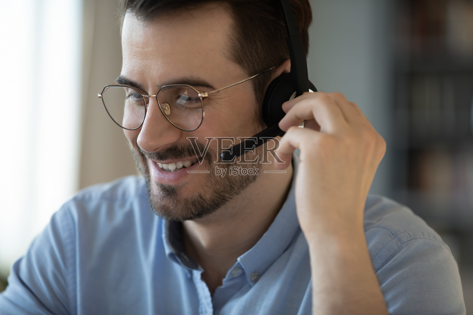 近距离微笑友好的男人戴着耳机在麦克风讲话照片摄影图片