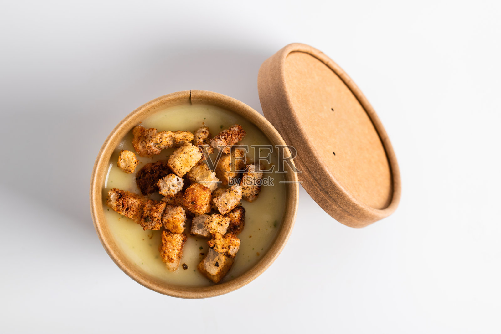 奶油土豆汤和面包丁在工艺容器在白色的背景。蔬菜汤外带，外卖照片摄影图片