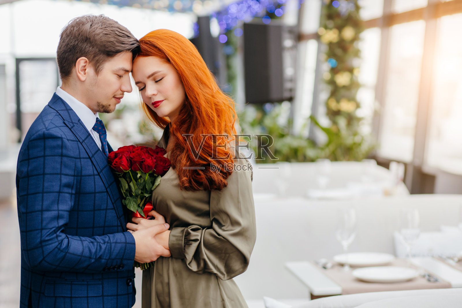 穿着燕尾服的帅哥和穿着红发礼服的女士在约会照片摄影图片