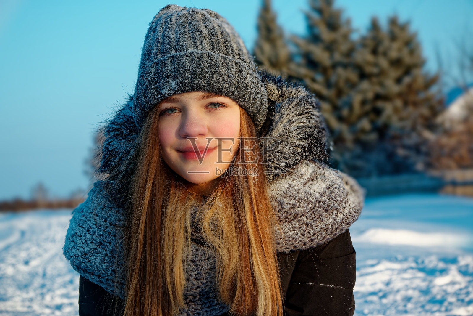 白色漂亮的年轻女孩穿着冬天的衣服在街上。照片摄影图片
