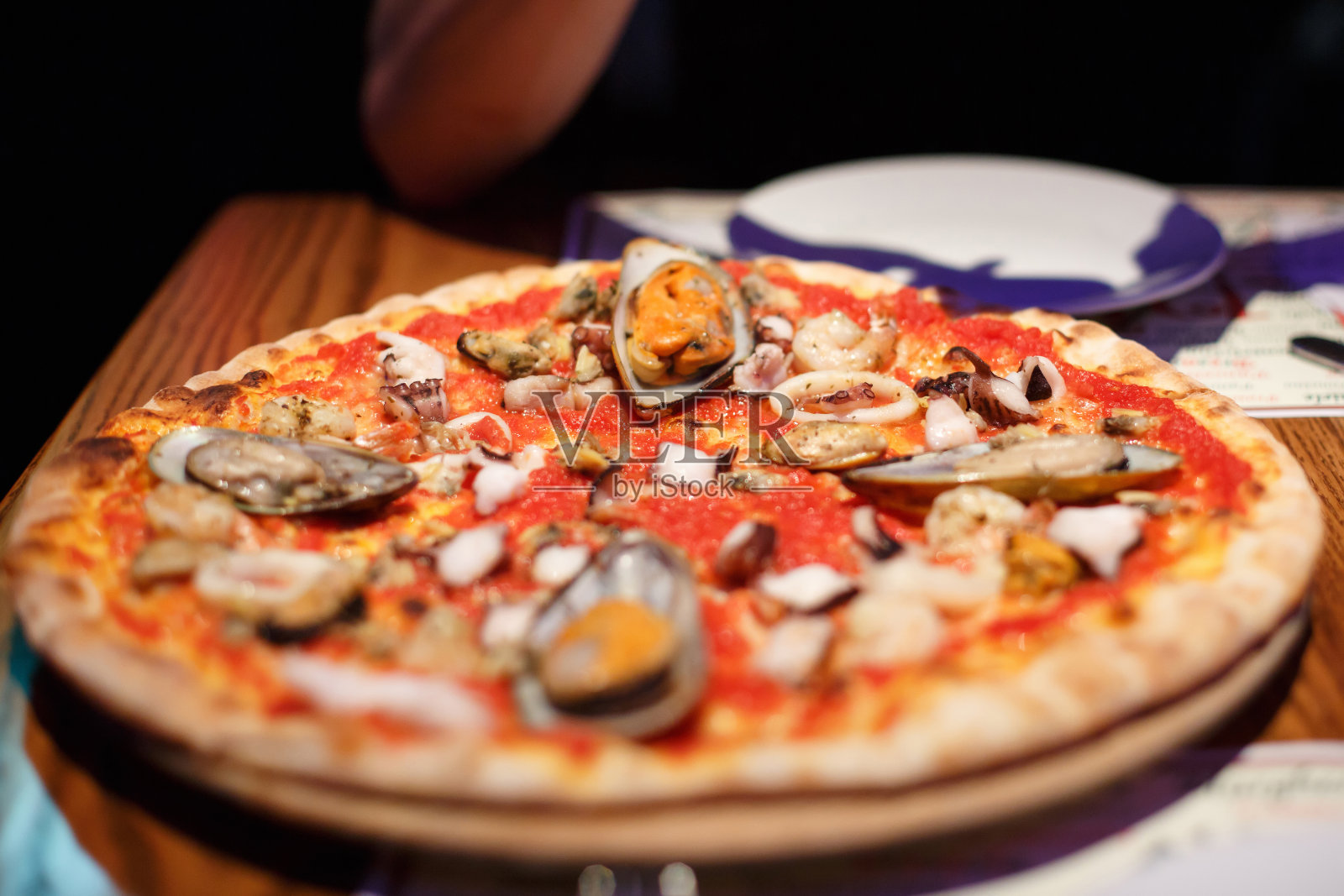 餐馆里的食物。海鲜和贻贝披萨照片摄影图片