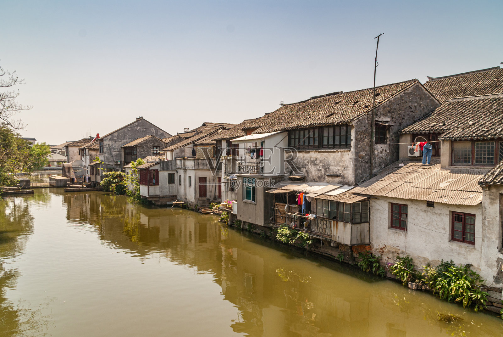中国同里运河上映出一行行肮脏的穷房子。照片摄影图片