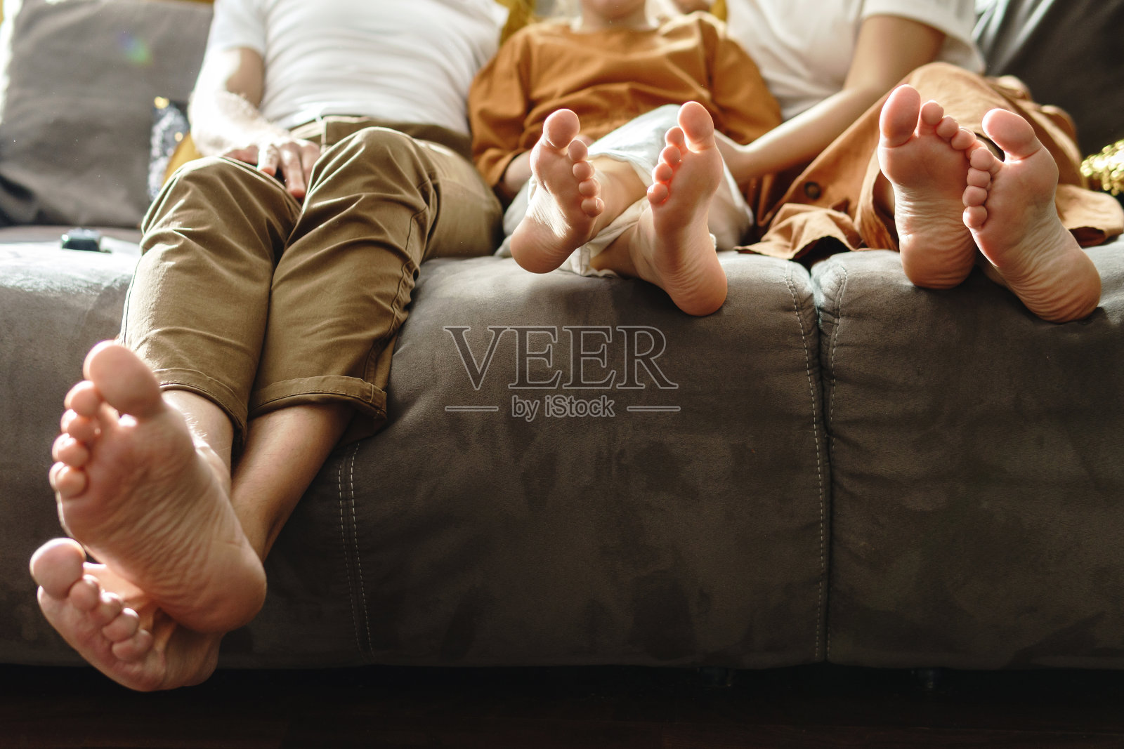 一家人赤脚坐在沙发上照片摄影图片