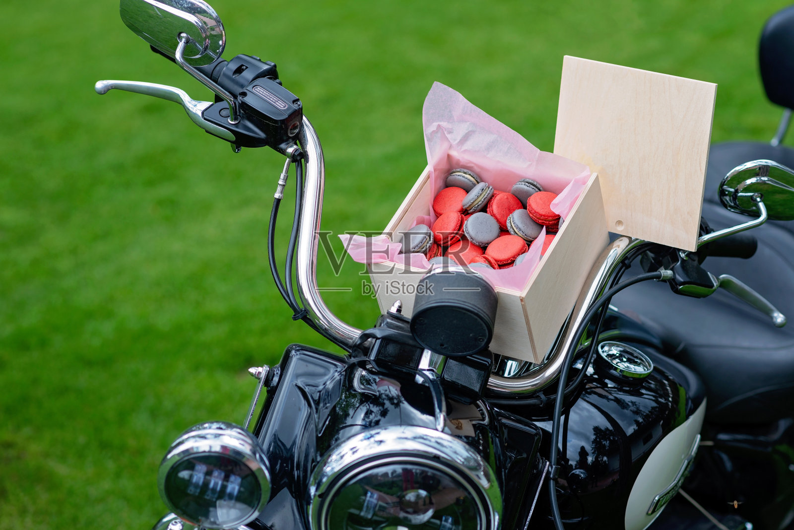 红色和灰色的法国榛子杏仁饼干装在木制礼品盒里放在户外摩托车上。糖果。软选择聚焦。照片摄影图片
