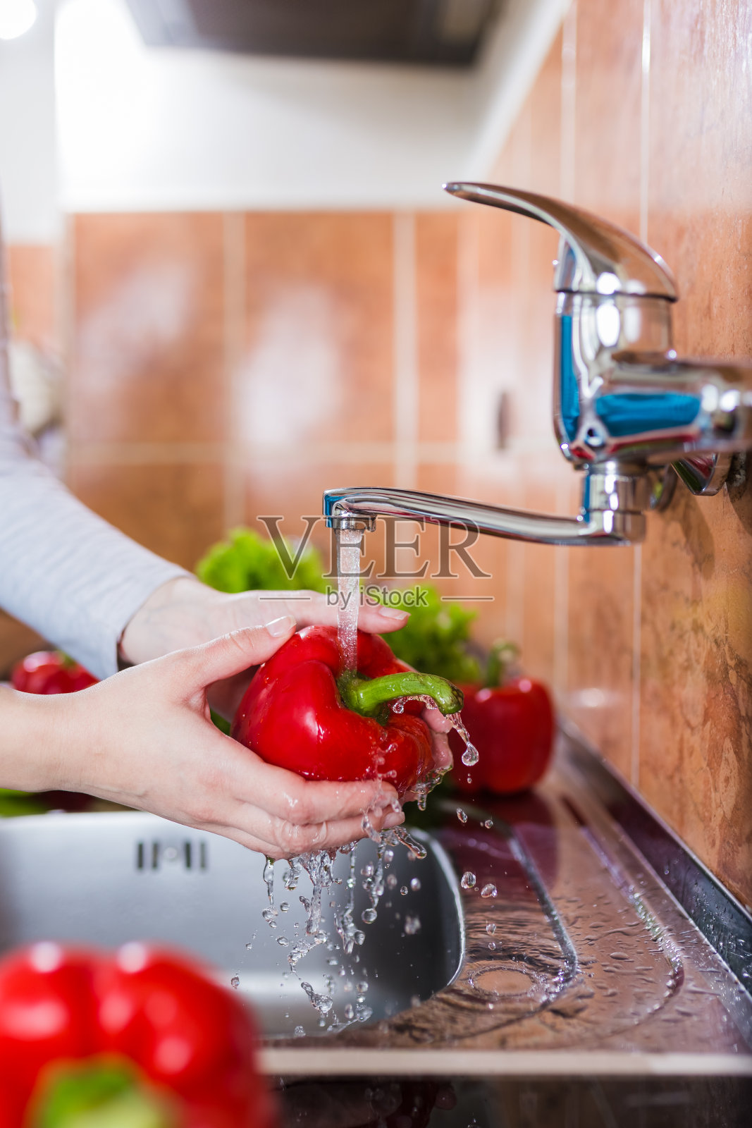 近距离女人的手洗蔬菜在现代厨房。照片摄影图片