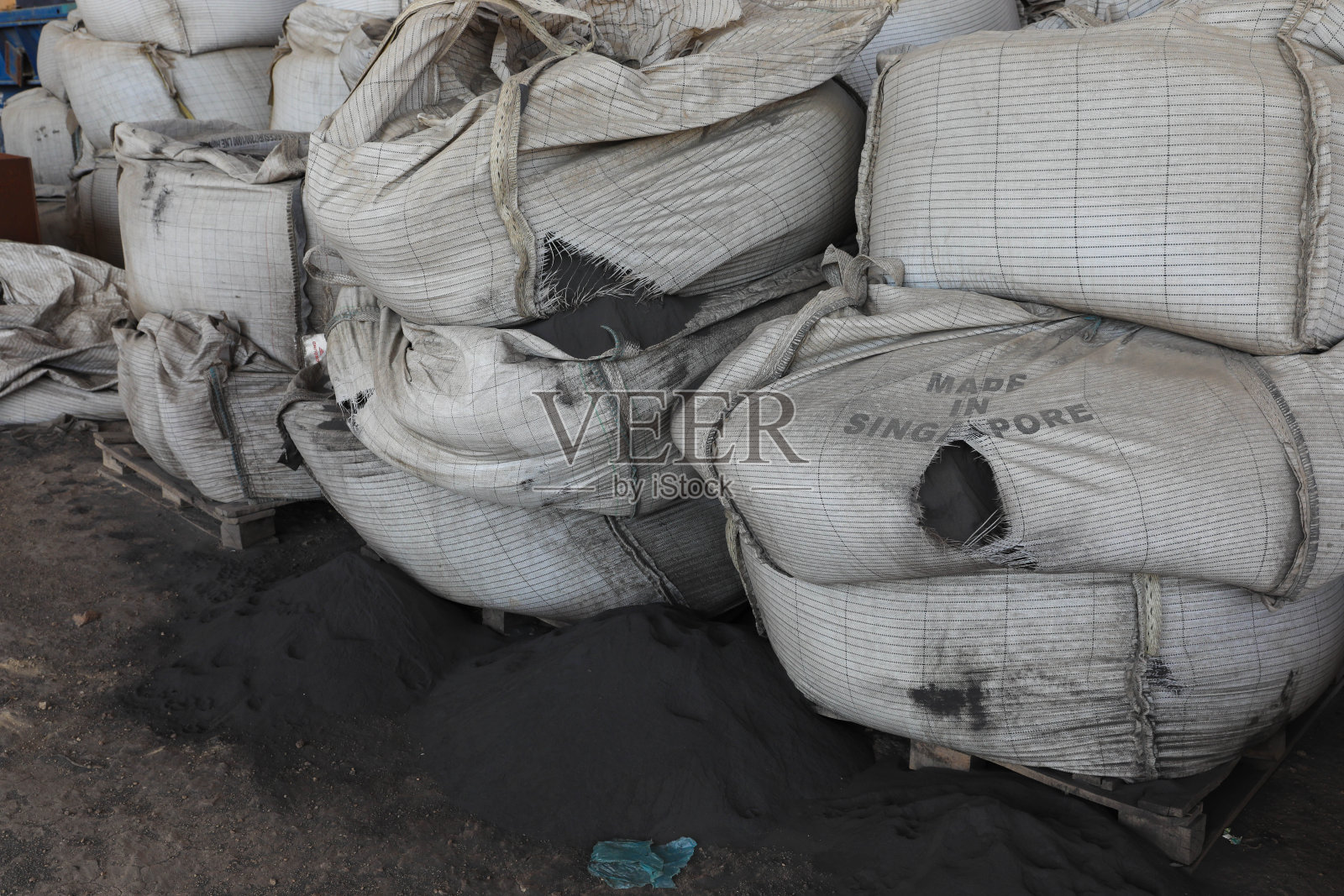 在沙特阿拉伯吉达的一家工厂里，一堆水泥袋，照片摄影图片