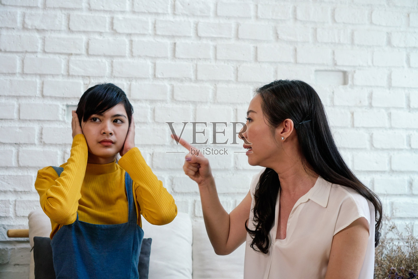 争吵恼怒的亚洲十几岁的女儿和沮丧的中年母亲。照片摄影图片