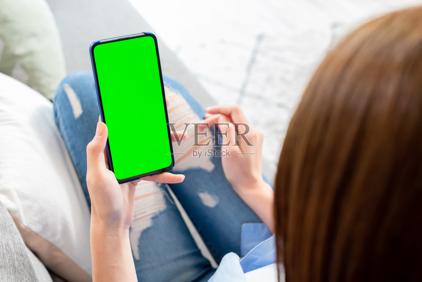 女人手持绿屏智能手机照片摄影图片