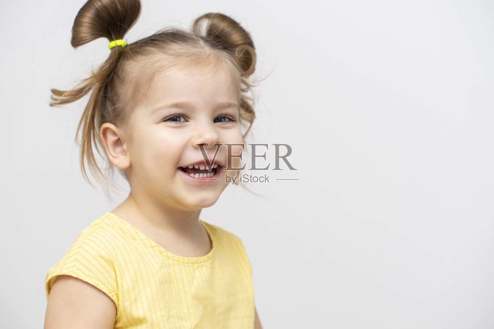 一个4-5岁穿着黄色t恤的小女孩笑了。向右复制空格照片摄影图片