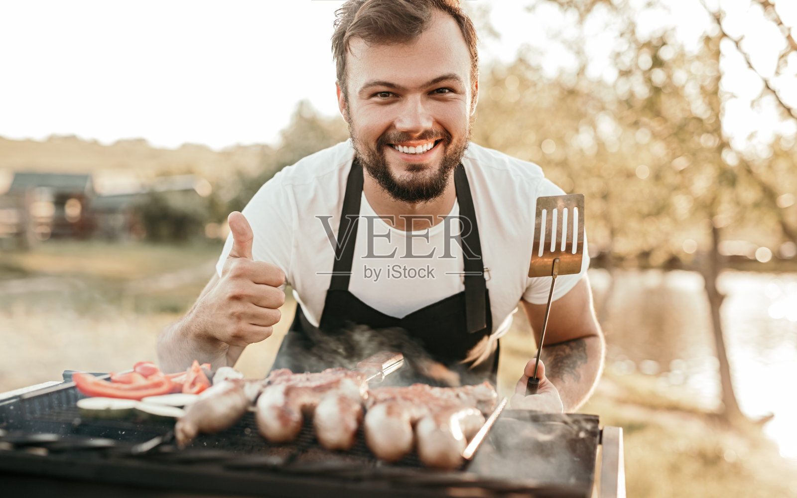快乐的人在火盆上烤香肠照片摄影图片