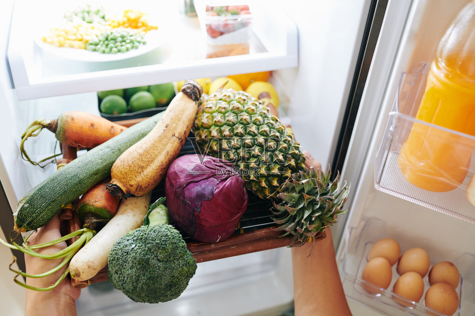 从冰箱里拿出蔬菜的人照片摄影图片