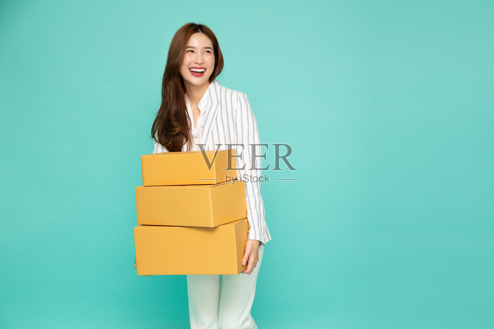 快乐亚洲女人抱着包裹箱孤立在浅绿色背景下，快递和托运的服务理念照片摄影图片