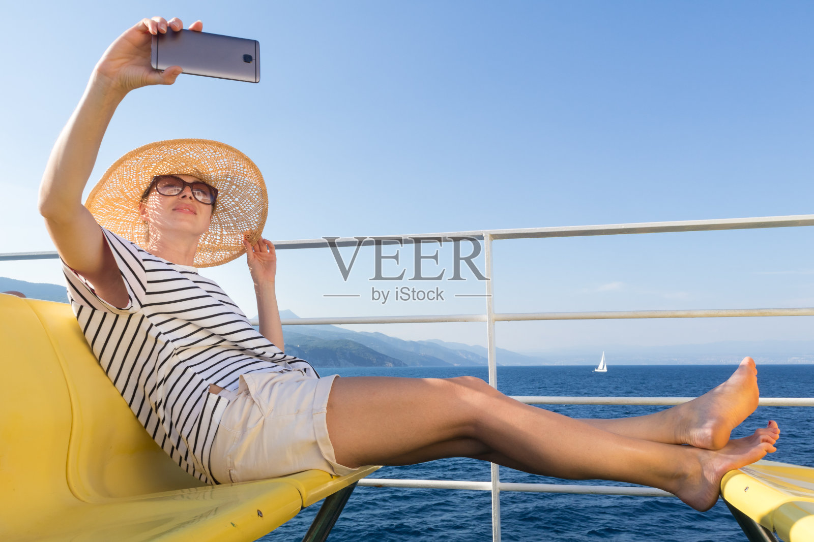 美丽，浪漫的金发女人自拍自拍照片在暑假旅行乘游轮渡船。照片摄影图片