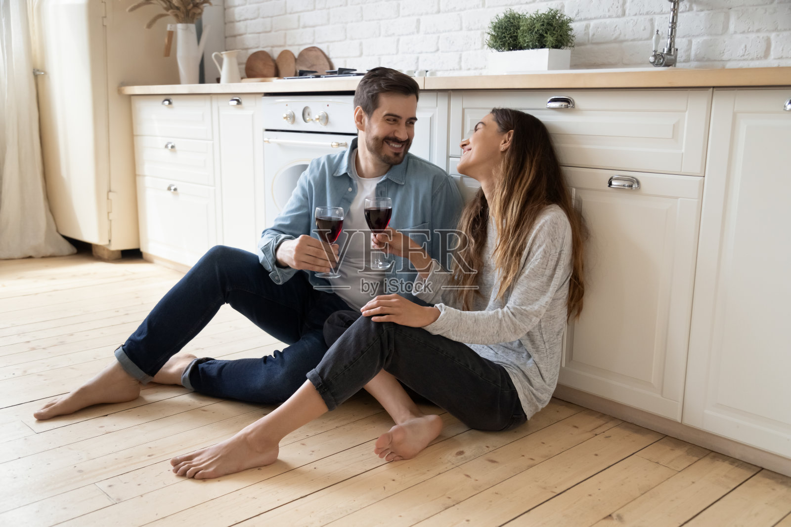 幸福的情侣坐在地板上，在家里进行浪漫的约会照片摄影图片