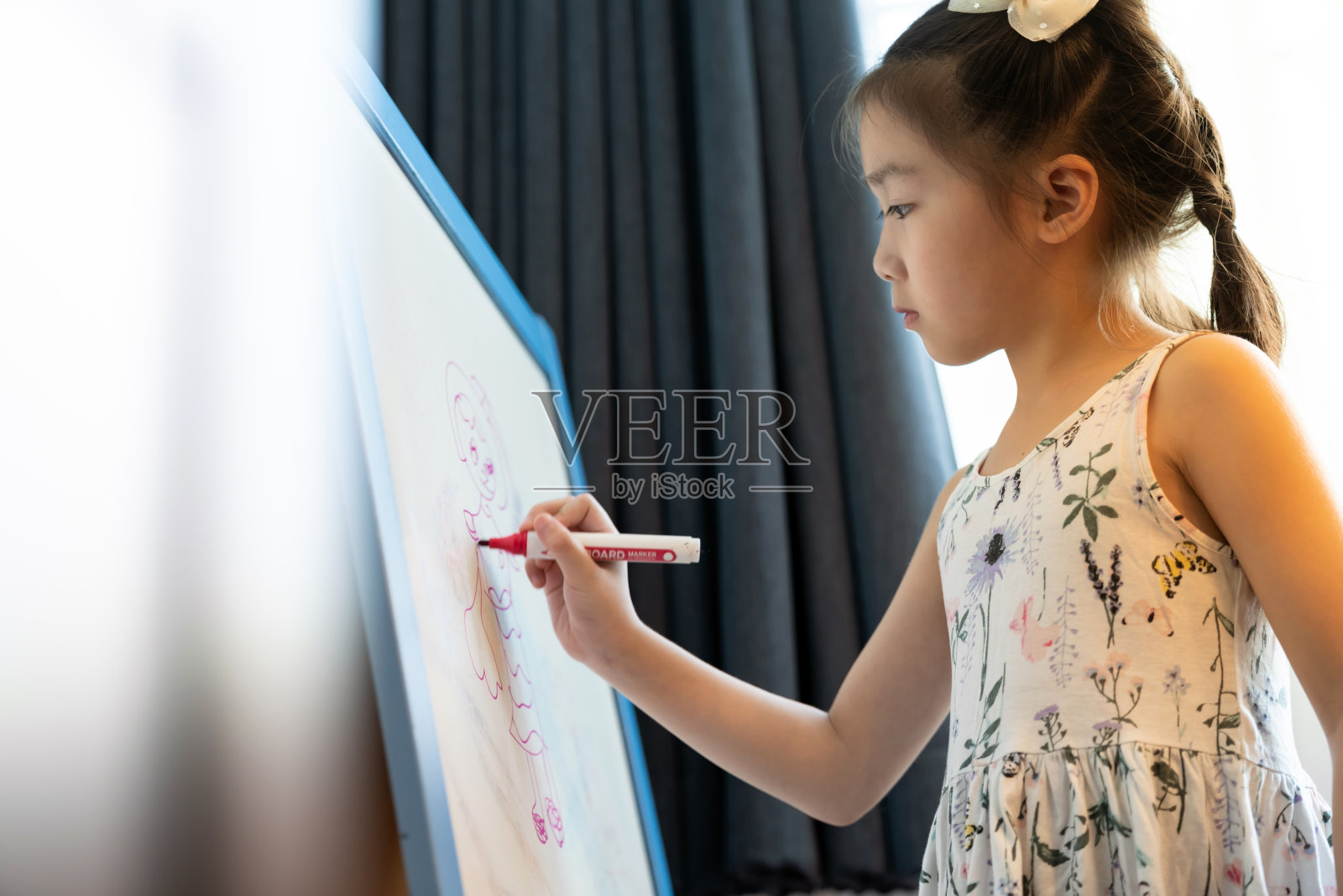 亚洲女小学生在白板上画画照片摄影图片