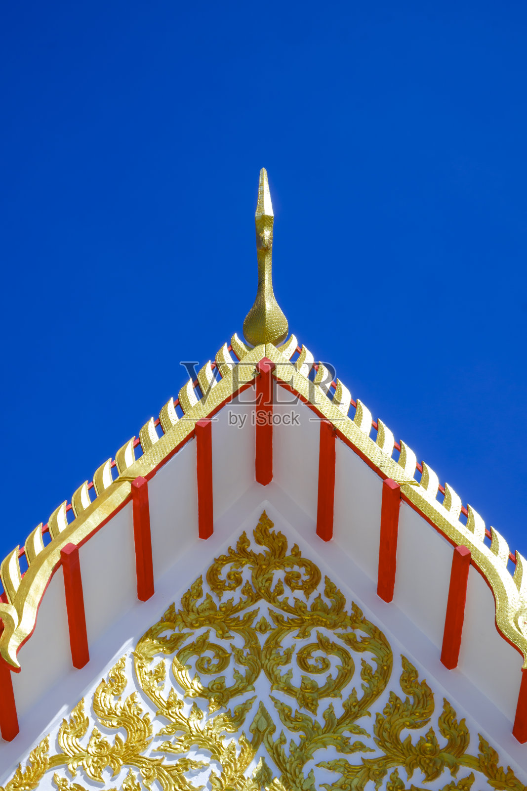 金色山墙顶端的装饰泰国寺庙屋顶，在垂直框架的蓝色清澈的天空背景照片摄影图片