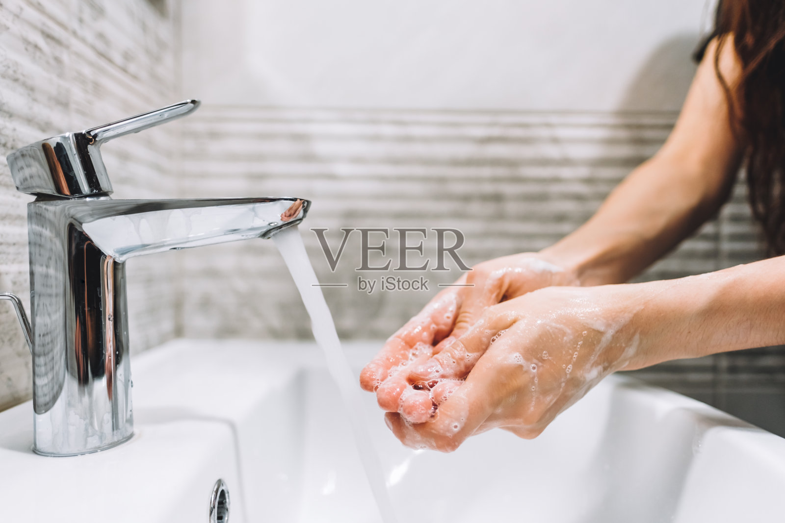 妇女用肥皂水龙头洗手，预防病毒性疾病、冠状病毒感染。照片摄影图片