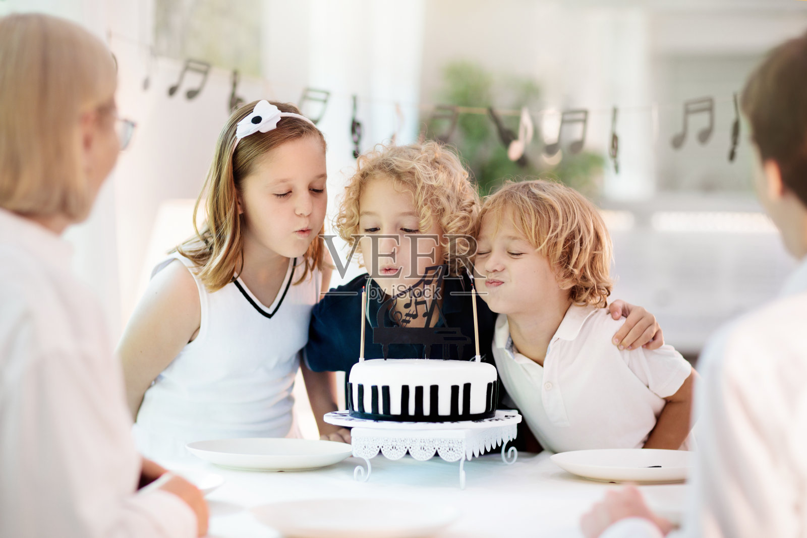 音乐和钢琴生日聚会。孩子与蛋糕。照片摄影图片