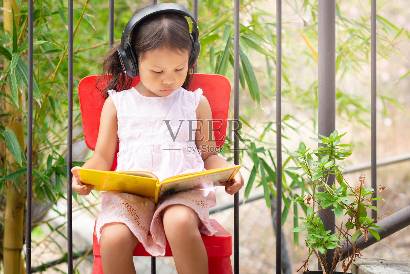 一个女孩在她的家外面看书。远程学习。照片摄影图片