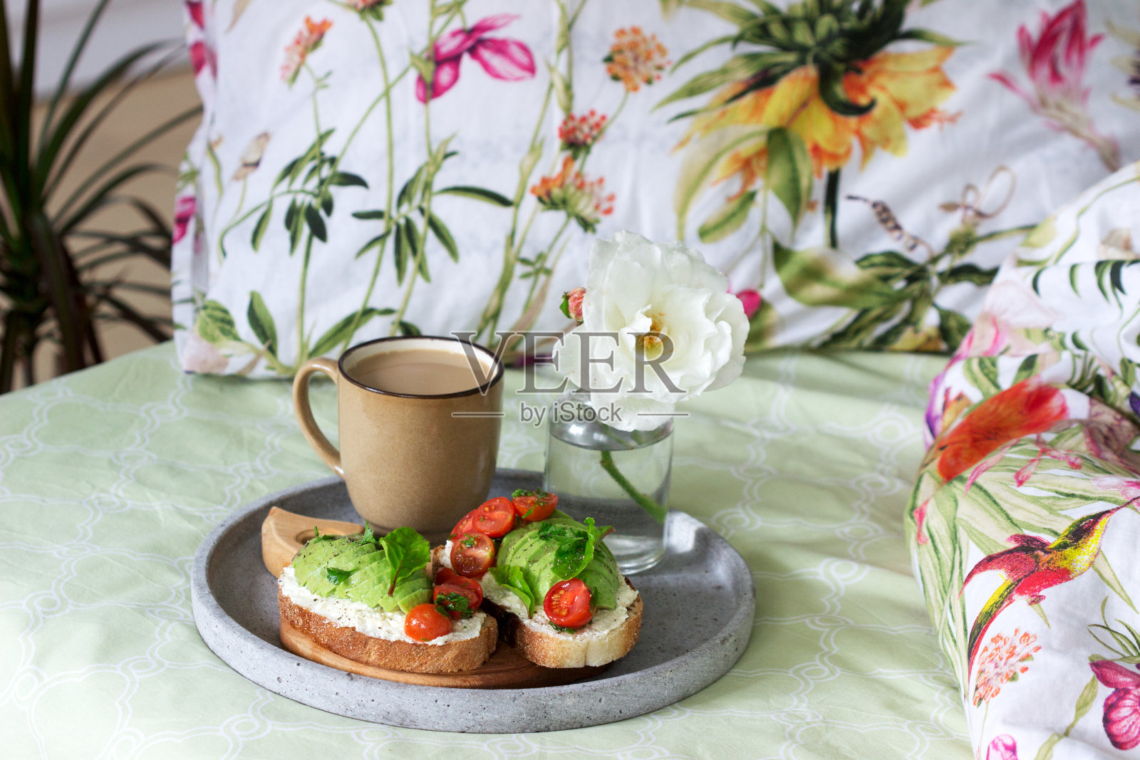早餐是三明治配干酪、牛油果、西红柿和咖啡，在床上吃。照片摄影图片