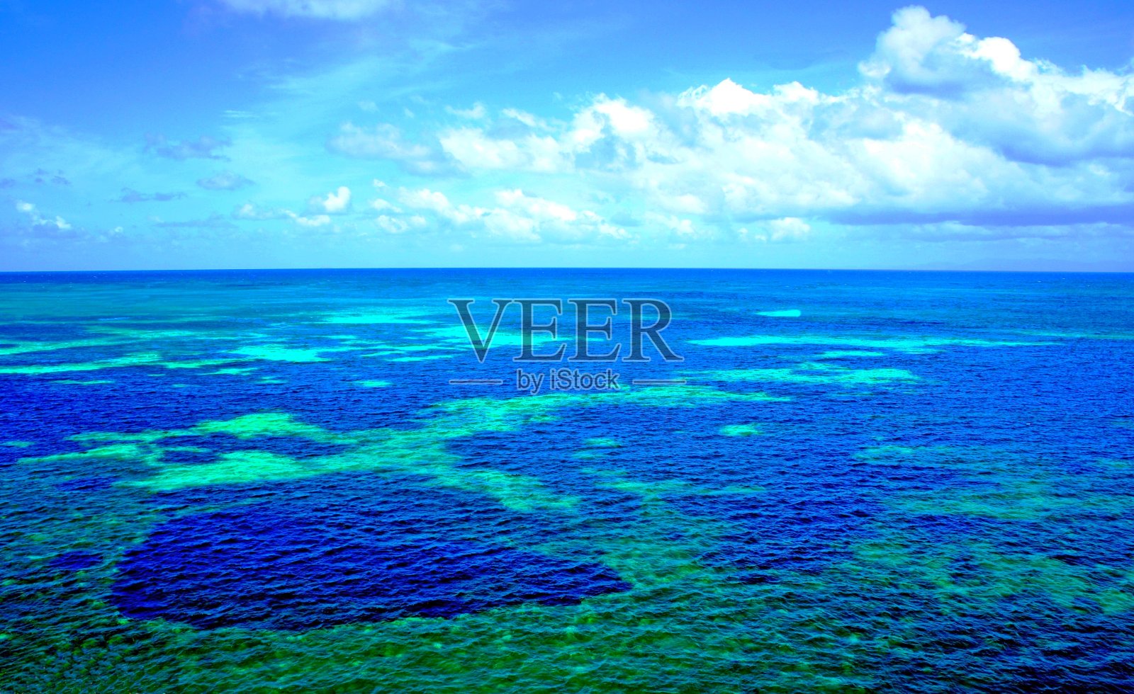 在塞舌尔群岛附近，美丽的蓝色印度洋表面和珊瑚礁。令人难以置信的夏季海蓝宝石的表面。风景海景。海水的质地和颜色。海洋背景照片摄影图片