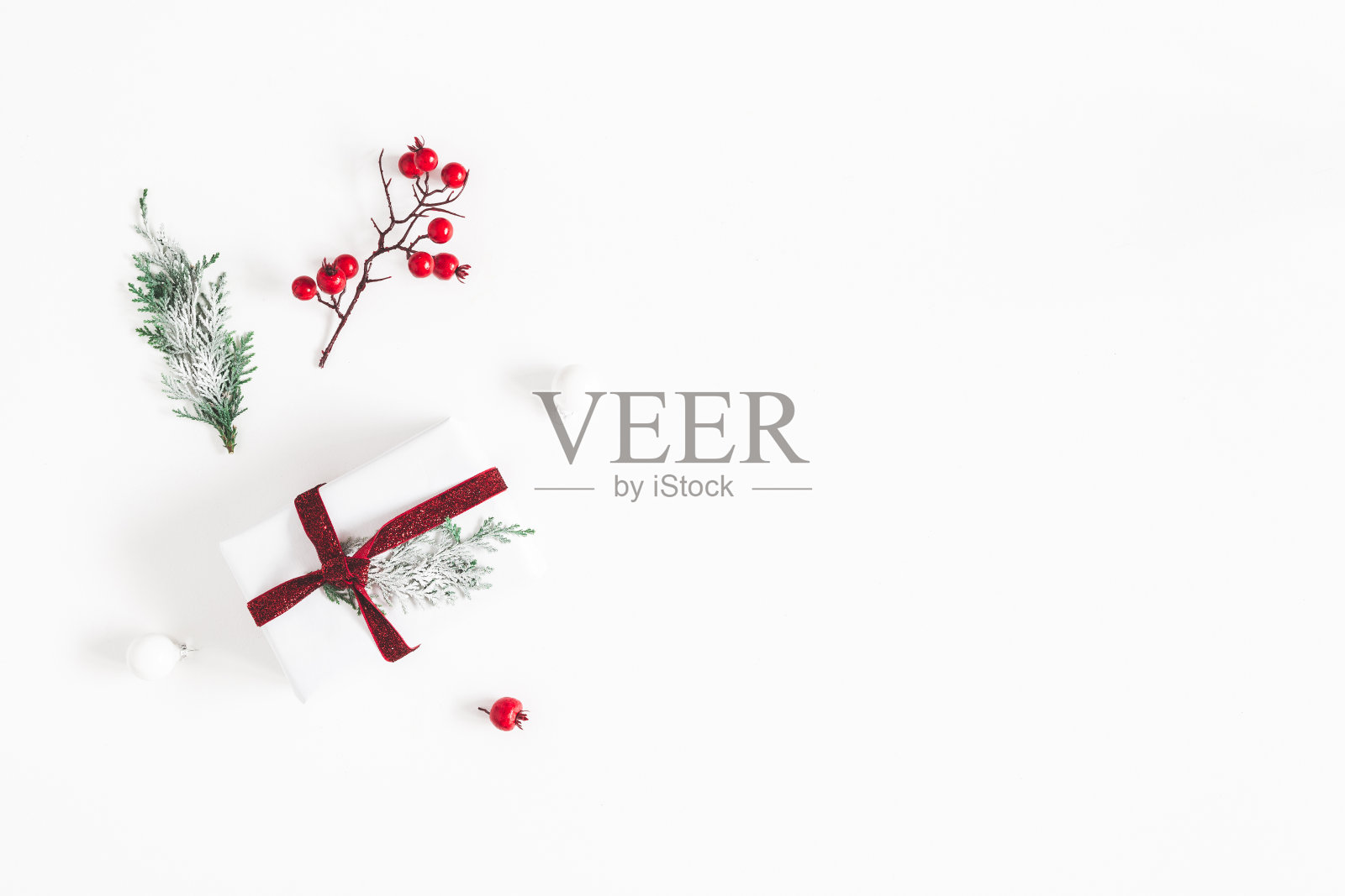 圣诞组成。由礼物、雪花、冷杉树枝和红浆果在白色的背景上制成的框架。圣诞节，冬天，新年的概念。平躺，俯视图照片摄影图片