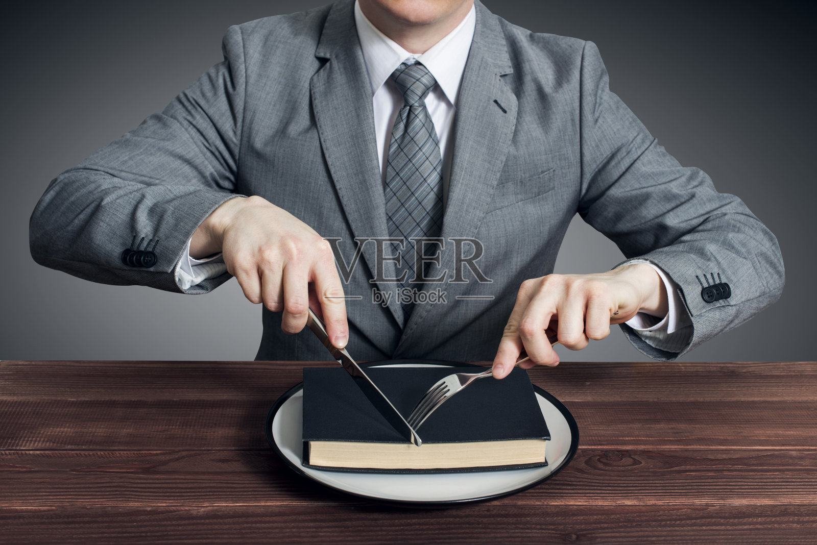 一个商人用刀叉在盘子里吃了一本书。52、理念教育，专业发展照片摄影图片