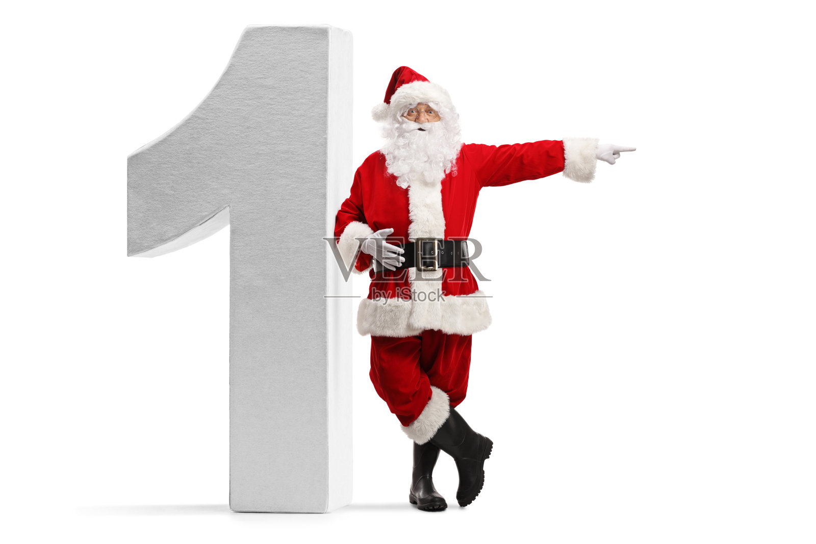 圣诞老人的全身像指向一边，靠在一个巨大的数字1孤立在白色的背景照片摄影图片