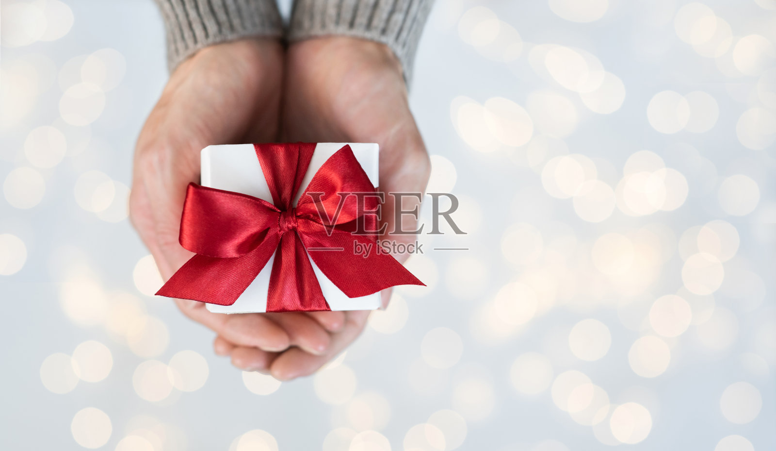 女人拿着圣诞礼物，礼物盒与红色缎带在明亮的背景照片摄影图片
