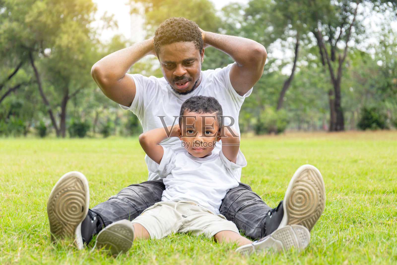 快乐的非裔美国父亲和儿子在公园里玩耍锻炼，幸福的家庭观念照片摄影图片