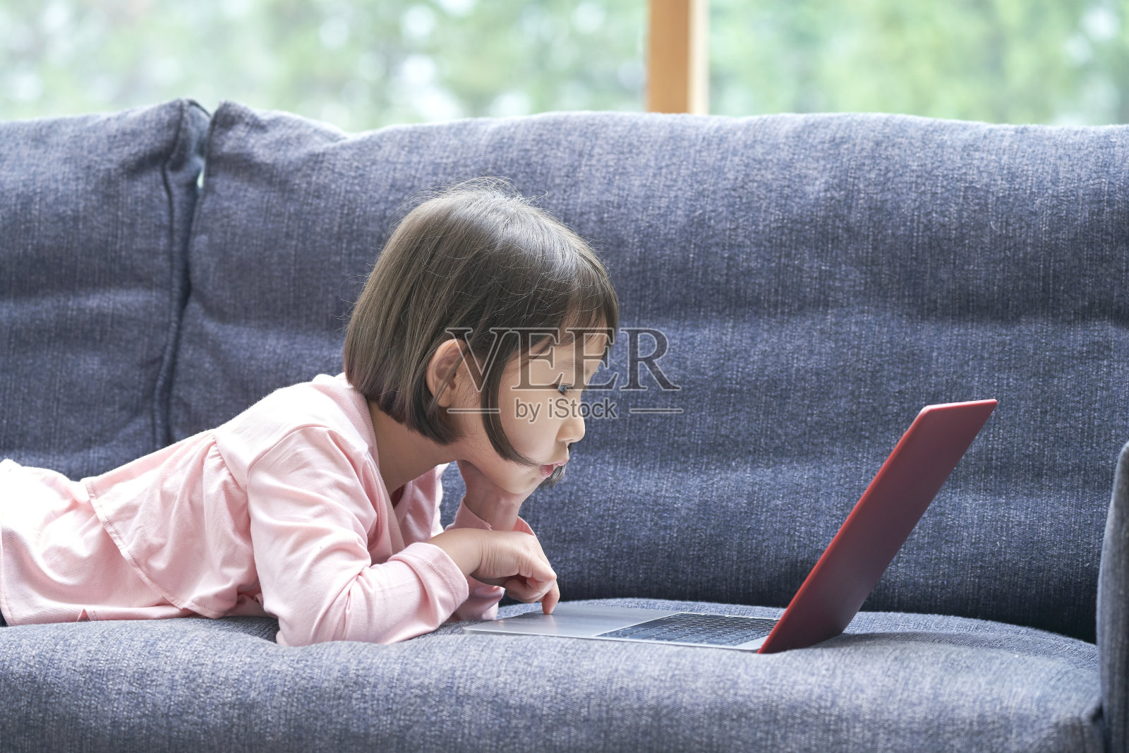 一个亚洲女孩在沙发上用笔记本电脑照片摄影图片