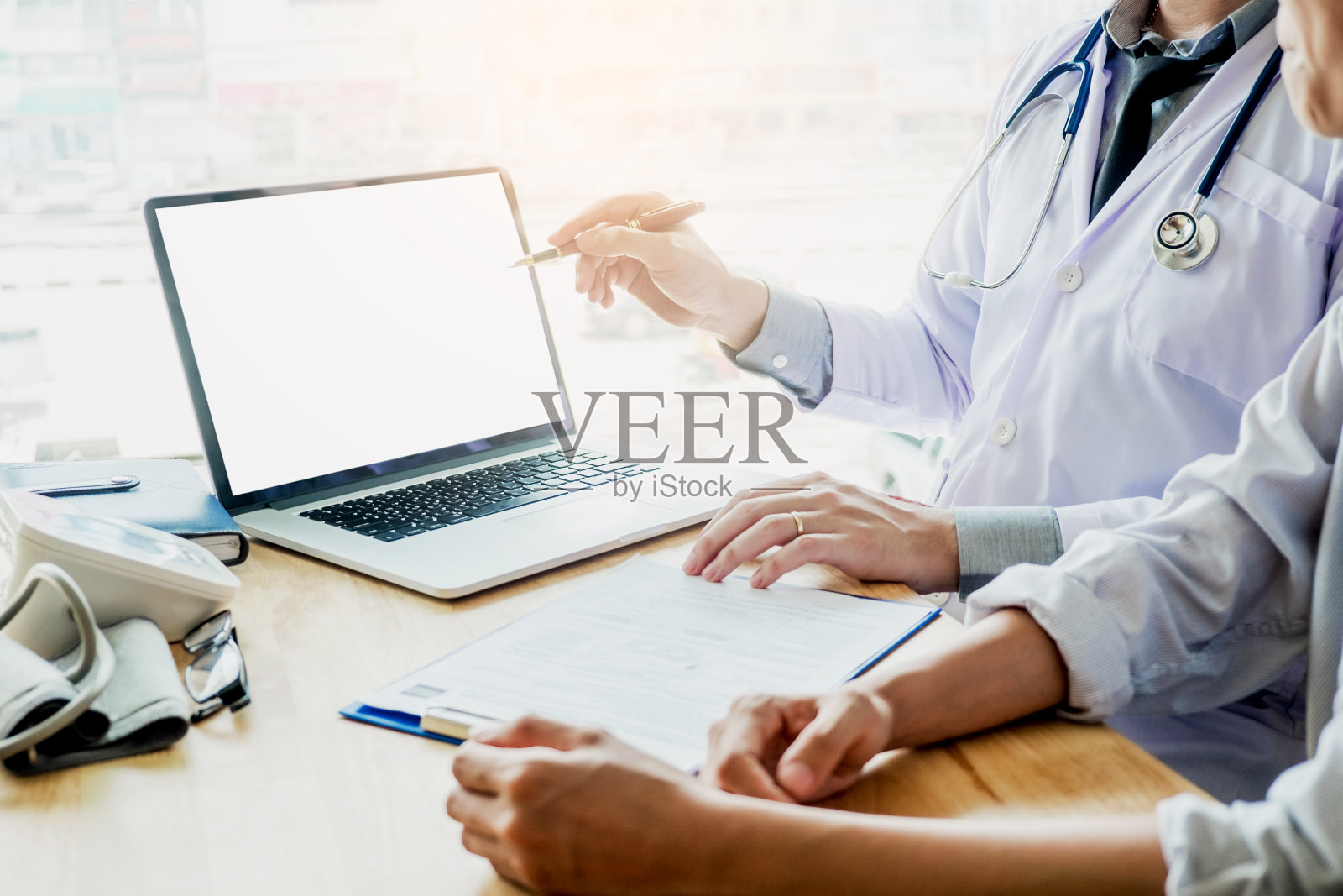 医生在桌子前的空白屏幕平板电脑上向病人展示检查结果照片摄影图片