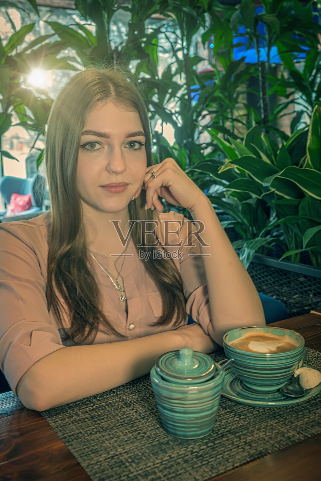 坐在自助餐厅里的漂亮女士面前端着牛奶咖啡照片摄影图片