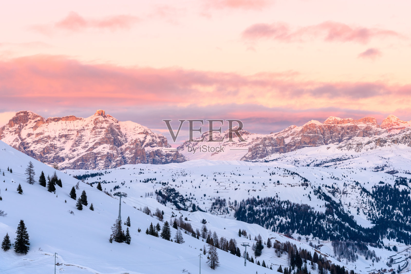 雪白的岩石山峰在黄昏的光线下闪着粉红色的光照片摄影图片