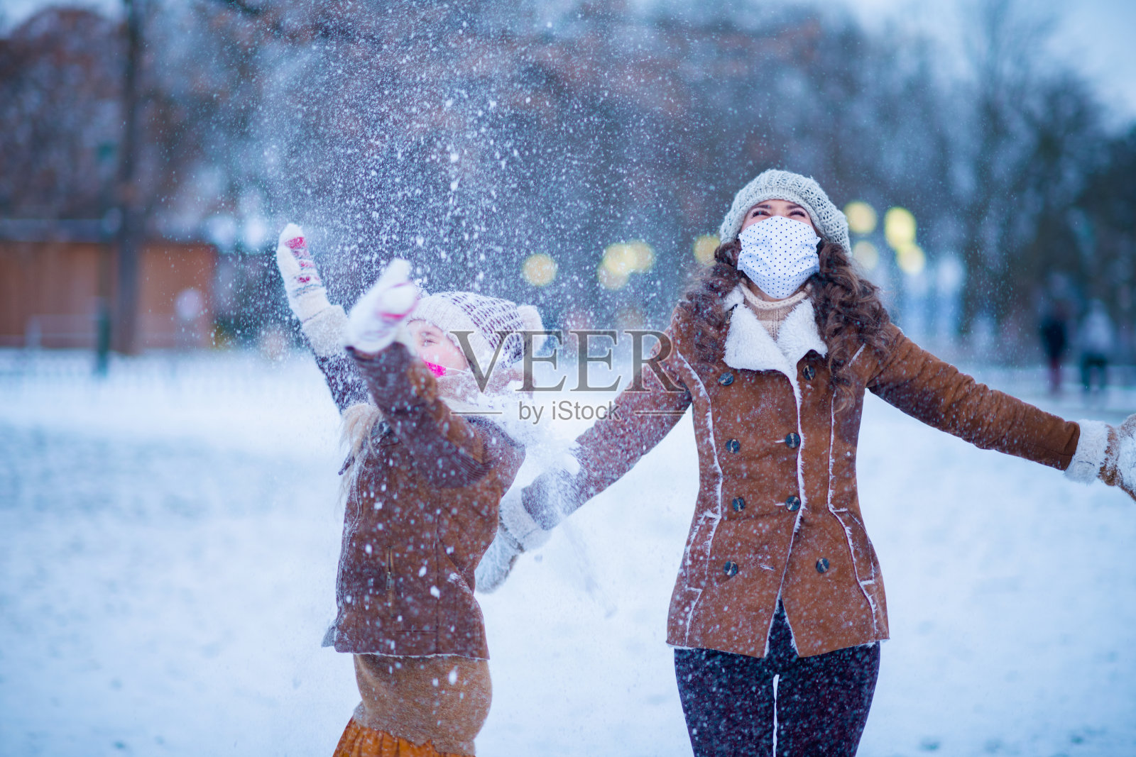 母亲和孩子在室外的城市公园在冬天照片摄影图片