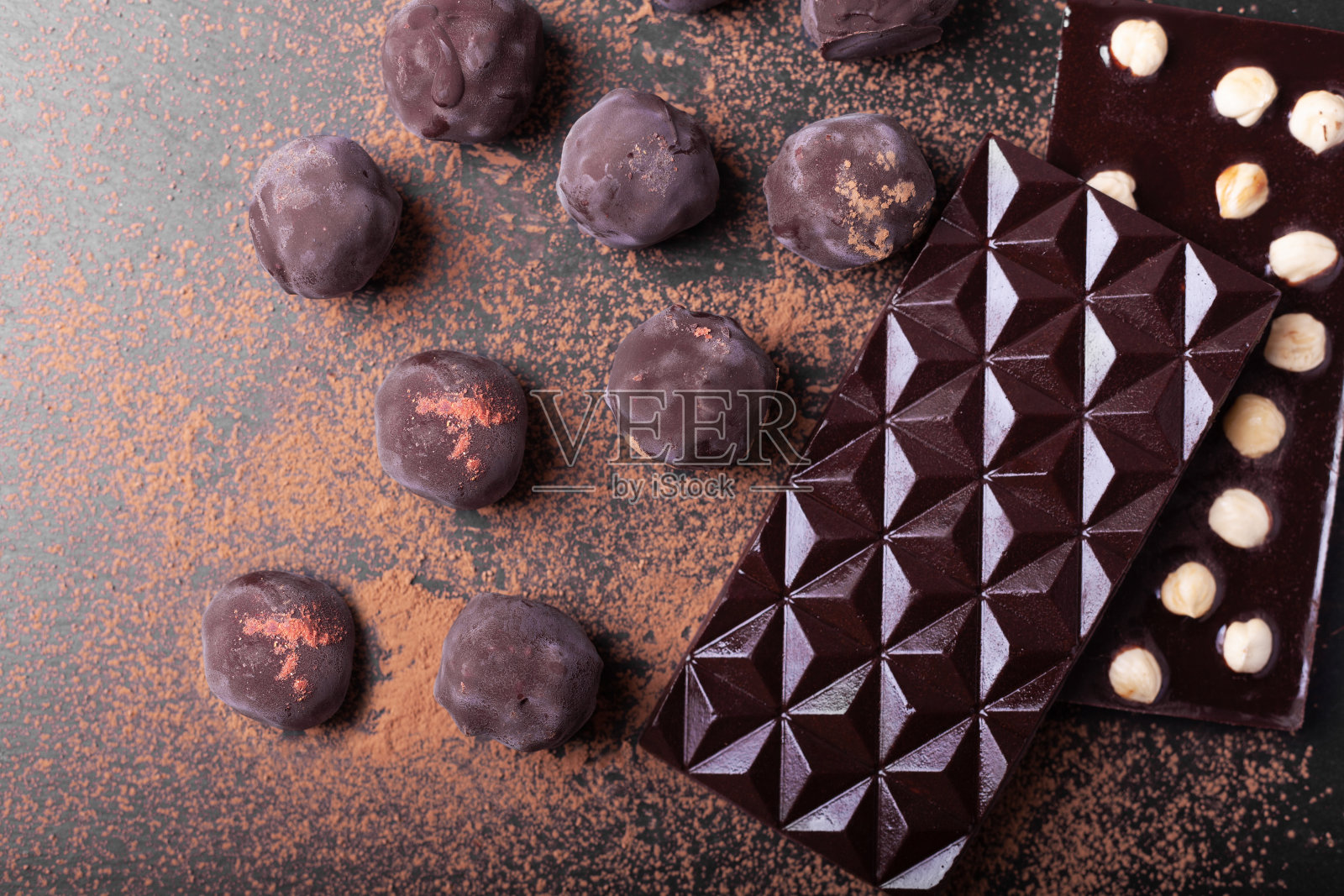 手工制作Ð’大理石巧克力和可可粉。黑色背景上的巧克力块照片摄影图片