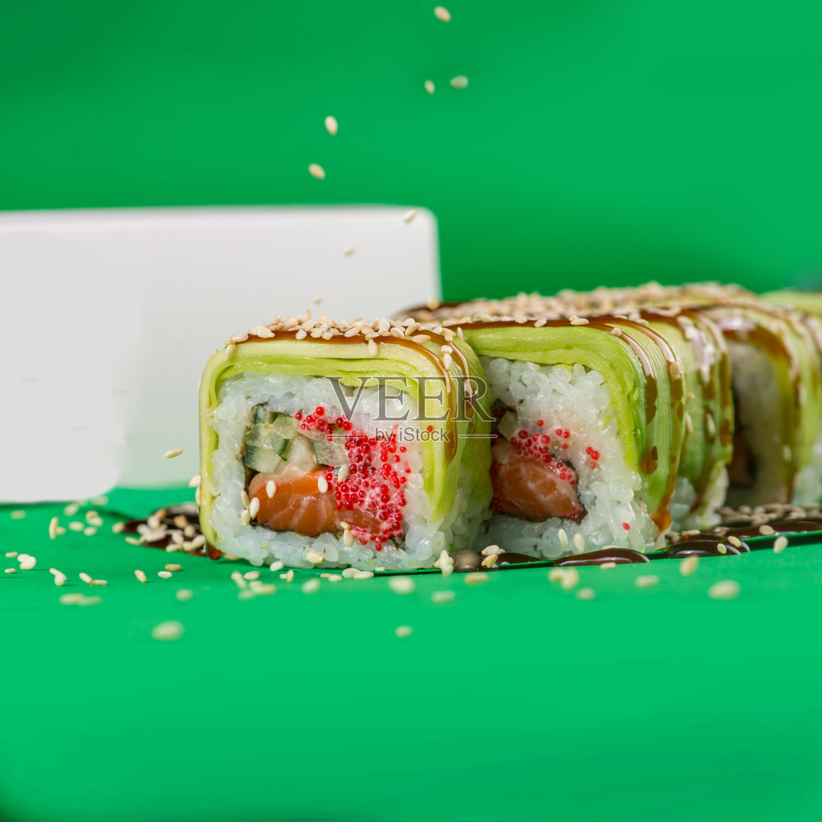 绿色背景上的鳄梨和奶油芝士寿司。特写镜头照片摄影图片