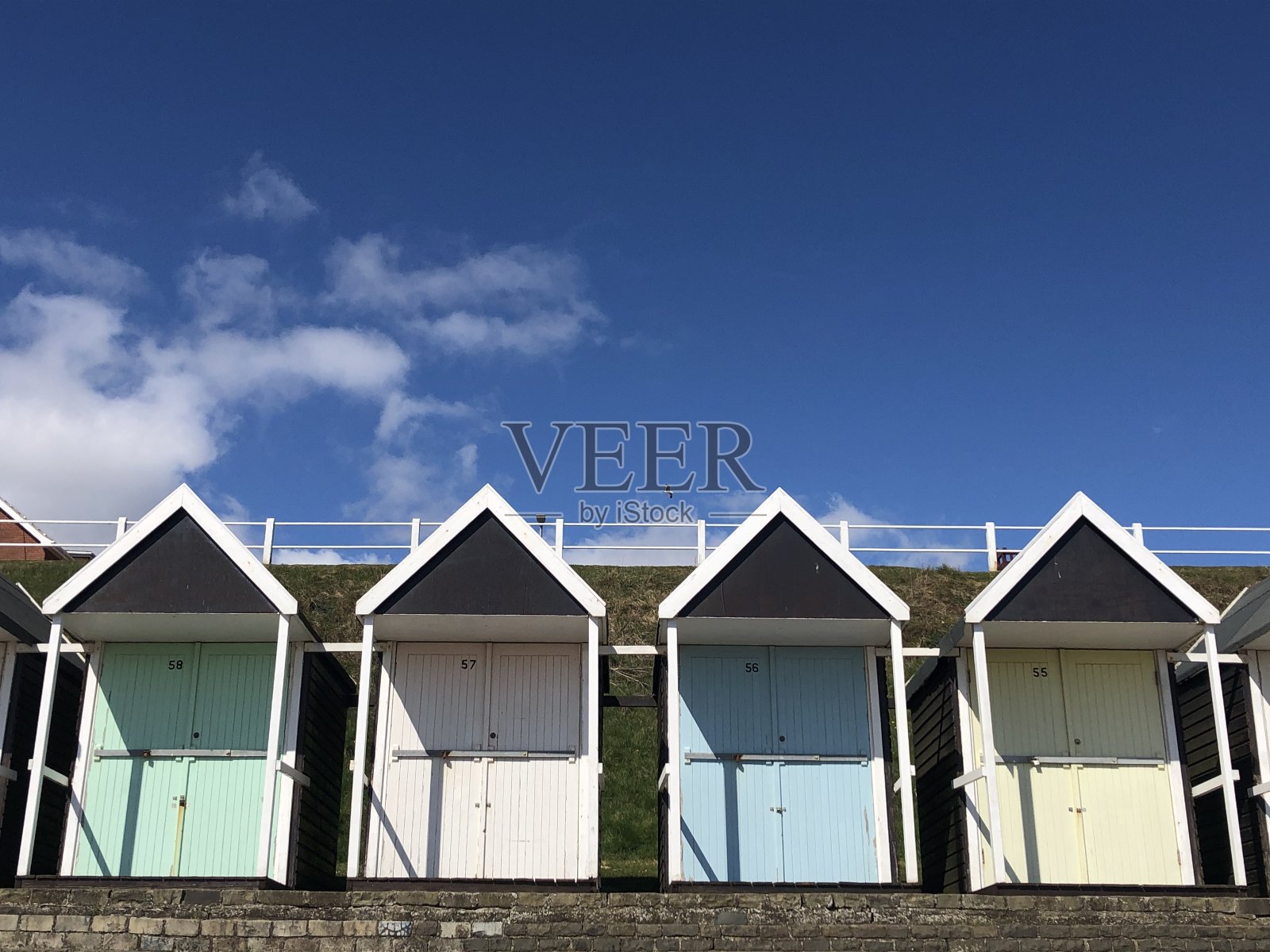 英国海滨度假胜地的一排色彩缤纷的复古海滩小屋照片摄影图片