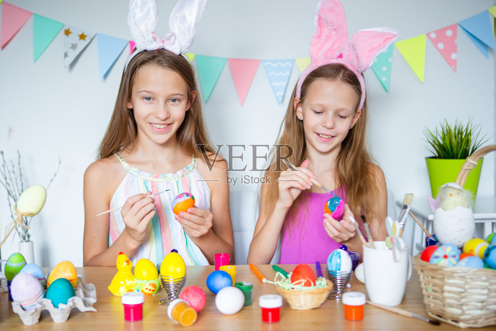 复活节快乐。复活节那天，漂亮的孩子们戴着兔子耳朵。照片摄影图片