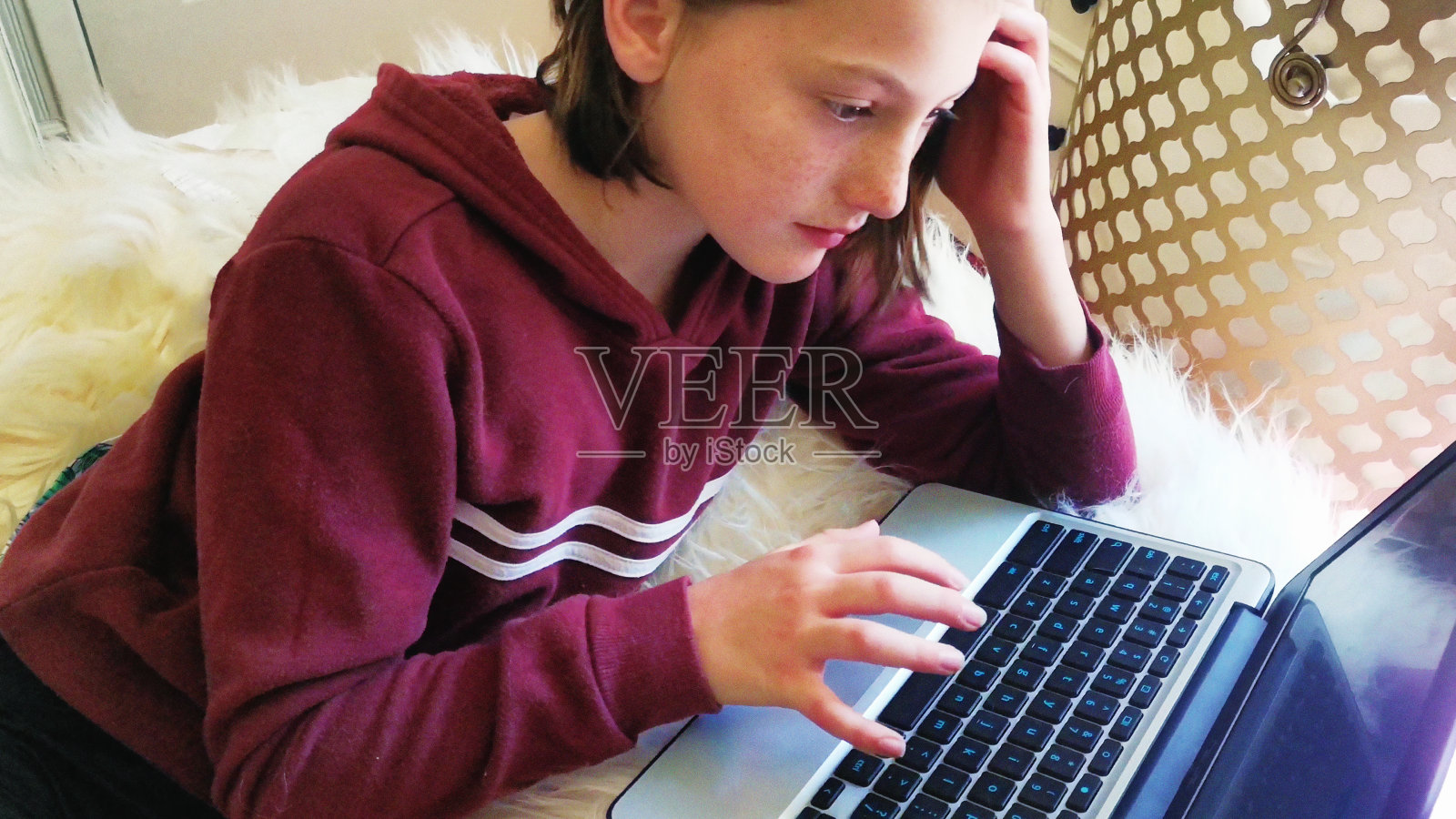 十多岁的女孩用笔记本电脑做作业，表情沉思照片摄影图片